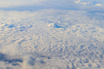 Beautiful white clouds in blue sky. View from airplane