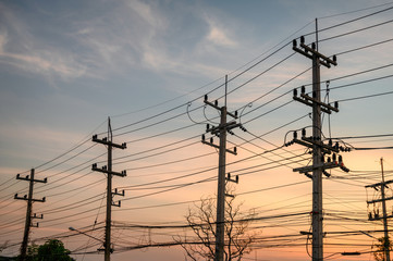 Rural rows of electricity pole with wires network on sunset