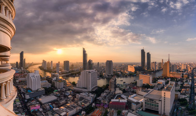 Cityscape of skyscraper with Chao Phraya river at sunset in Bangkok