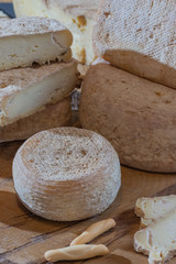 Various sliced cheese on wooden background