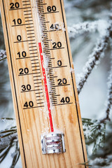 thermometer with subzero temperature stuck in the snow in the winter forest