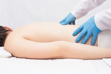 The doctor performs a massage and examination of the patient who has a back ache, medicine, copy space