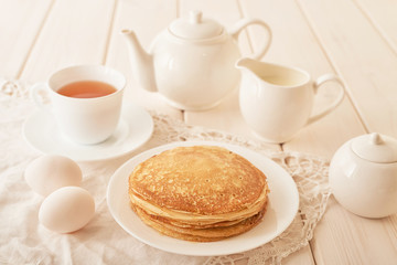 Healthy summer breakfast, homemade classic american pancakes with honey,cozy morning, copy space. Pancakes, teapot, honey on white wooden table. Pancake week. russian traditional holiday Maslenitsa