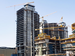 High-rise buildings under construction with cranes and scaffolding