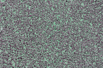 texture of a small dark stone with green sand