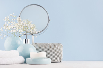 Dressing table with circle mirror, cosmetic silver accessories and white small flowers in ceramic...