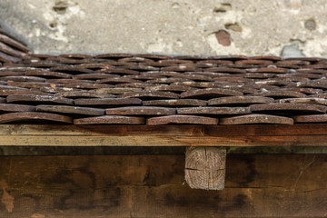 Close up of old roof with tiles and wooden beam