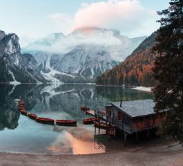 Boats keeps on the water. Good landscape with mountains. Touristic place with wooden building and pear