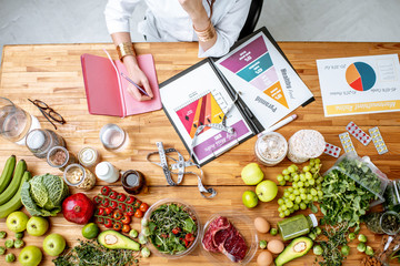 Dietitian writing diet plan, view from above on the table with different healthy products and...