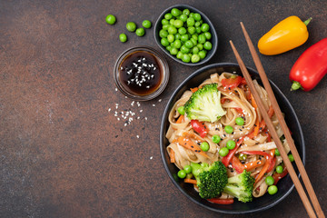 Noodles stir fry with vegetables. Udon noodles with broccoli, green pea, carrot, pepper and teriyaki sauce