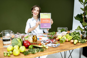 Dietitian promoting healthy balanced eating sitting at the table full of variuos products