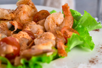 close-up of salad with king prawns on a plate on a light background