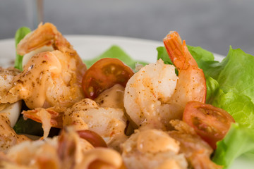close-up of salad with king prawns on a plate on a light background