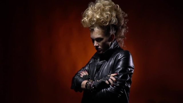 Cool rocker girl in leather jacket, with mohawk like hairstyle, posing