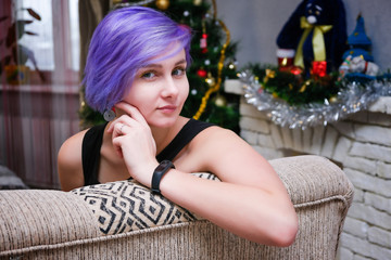 Obraz na płótnie Canvas I'm bored in the new year - Concept portrait of a beautiful girl with purple hair in a room sitting on a sofa and bored.