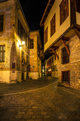 Fototapeta na wymiar Picturesque narrow alley and neoclassical buildings at night, characteristics in the old town of Xanthi.