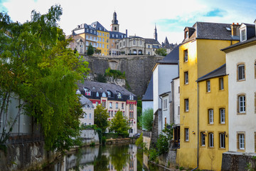 Alzette river crossing the old town of Luxembourg, Europe, with colorful typical houses and wall at the background
