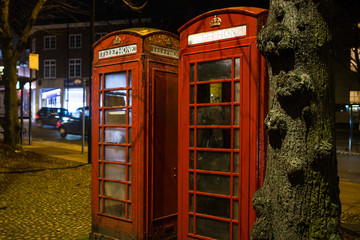 Two red phone boxes in an ancient city in the UK