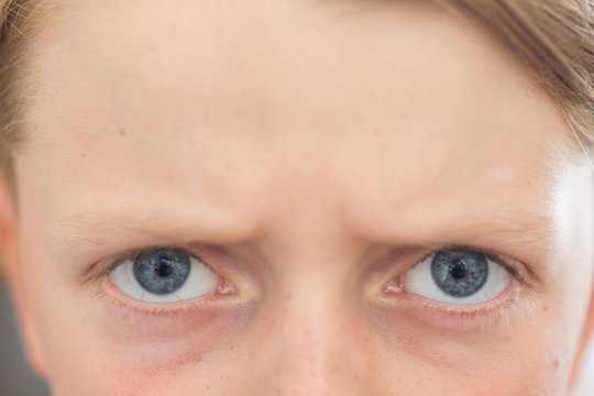 close up of an 8 year old's blue eyes with and angry expression