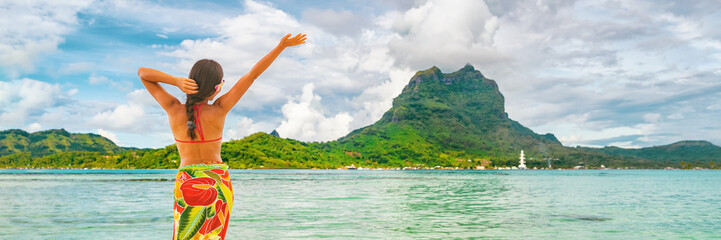 Happy Tahiti tourist travel woman enjoying freedom vacation in paradise. French Polynesia hula...