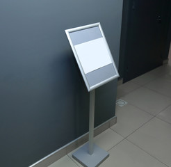 blank poster standing before the iron door.