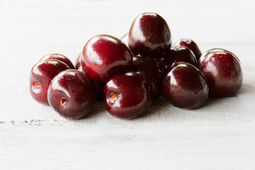 red sweet cherry on a light wooden background 