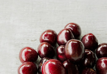 red sweet cherry on a light wooden background 