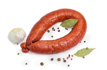 Ring bologna sausage among various spices on a white background