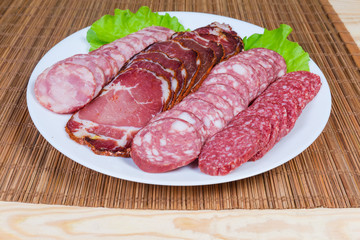 Sliced dried meat and different varieties of sausages close-up