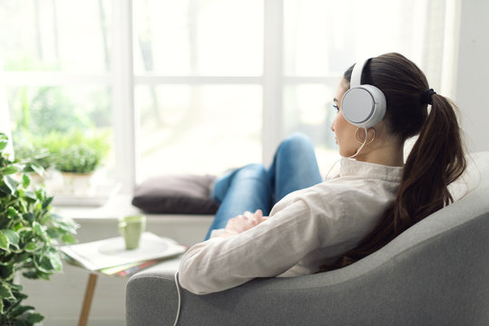 Woman relaxing on the couch and listening to music