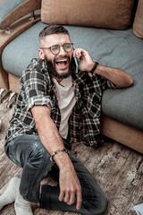 Obraz premium Joyful happy man enjoying his phone conversation