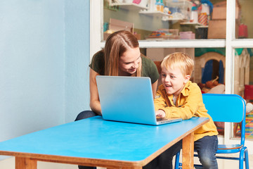 Lehrerin und Junge am Laptop Computer