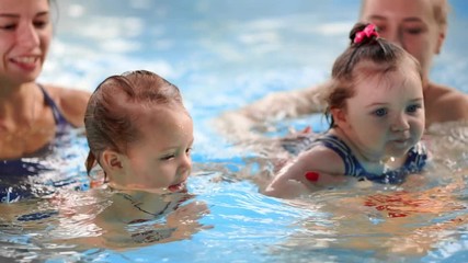 Group of mums with their baby children at infant swimming class