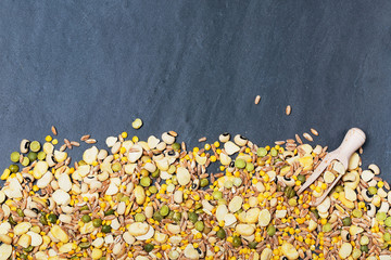 Mixed dried legumes and cereals one slate background, top view
