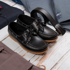 male loafers, belt and clothes on wooden background