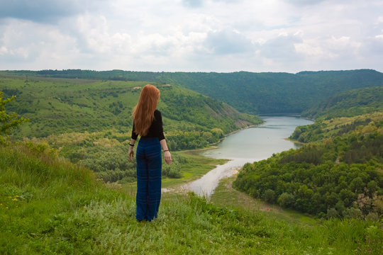 A beautiful girl tourist enjoys nature next to a mountain river Ternava