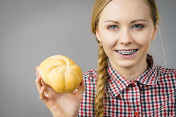 Woman holding bun bread roll.