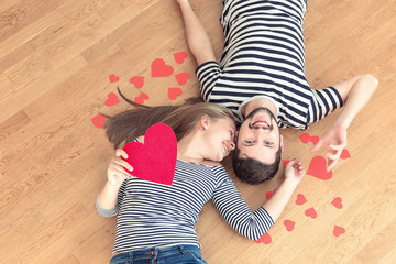 Top view young couple lying on the floor and looking to camera.