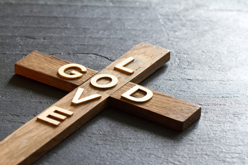 Easter christian wooden cross with an inscription god is love abstract religion background