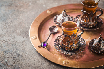 Obraz na płótnie Canvas Turkish tea in traditional glass on tray closeup