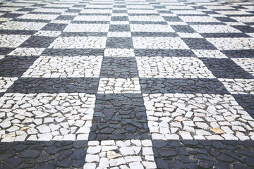 Old street road paved surface stone pavement walkway texture pattern Chess board. Granite cobblestones pavement background. Abstract background of old cobblestone pavement vintage style Europe.