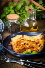 Piece of tasty hot lasagna with red wine.