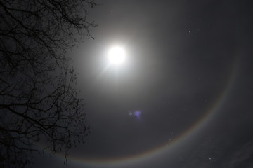 Moon halo phenomenon. Bright ring around the moon effect. Amazing and mysterious astronomical phenomenon over the night sky