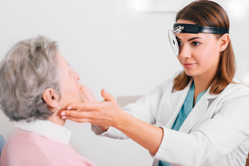 doctor palpating lymph nodes of aged patient, medical exam at doctor office