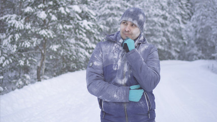 Fototapeta na wymiar Frozen man in the winter forest is thinking