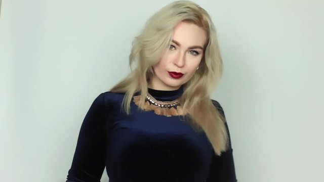 Beautiful young woman straightens blond hair