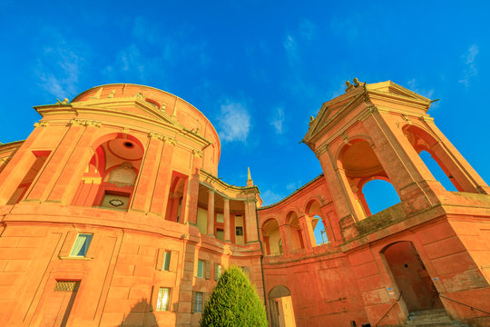 Bottom view of Sanctuary of Madonna di San Luca basilica church in a sunny day with blue sky. Cathedral of San Luca on the hills of Bologna, Emilia-Romagna, Italy. Famous landmark cityscape.