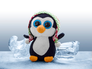 A plush penguin among lumps of ice.