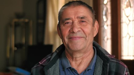Happy smiling healthy young looking senior man portrait. Closeup, slow motion 4K UHD.