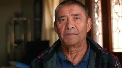 Serious elderly man portrait, looking at camera, closeup. 4K UHD.